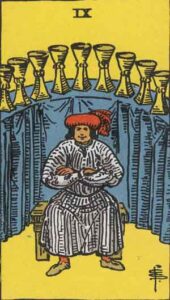 Illustration of the Nine of Cups tarot card, featuring a figure seated with a satisfied expression, surrounded by nine cups arranged on a backdrop of blue curtains.