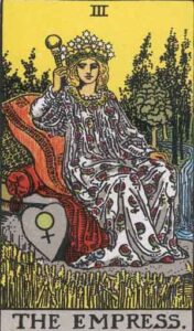 The Empress tarot card, featuring a crowned woman seated on a throne adorned with flowers, symbolizing abundance, creation, and the divine feminine.