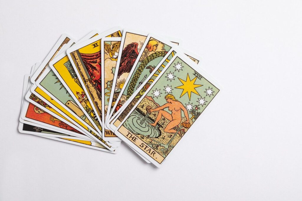 A fanned Rider-Waite-Smith tarot deck on a white surface, with The Star card on top